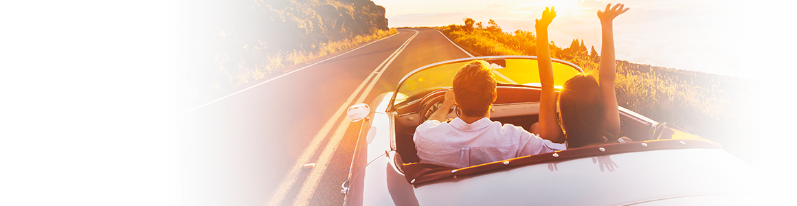 couple driving down road during sunset